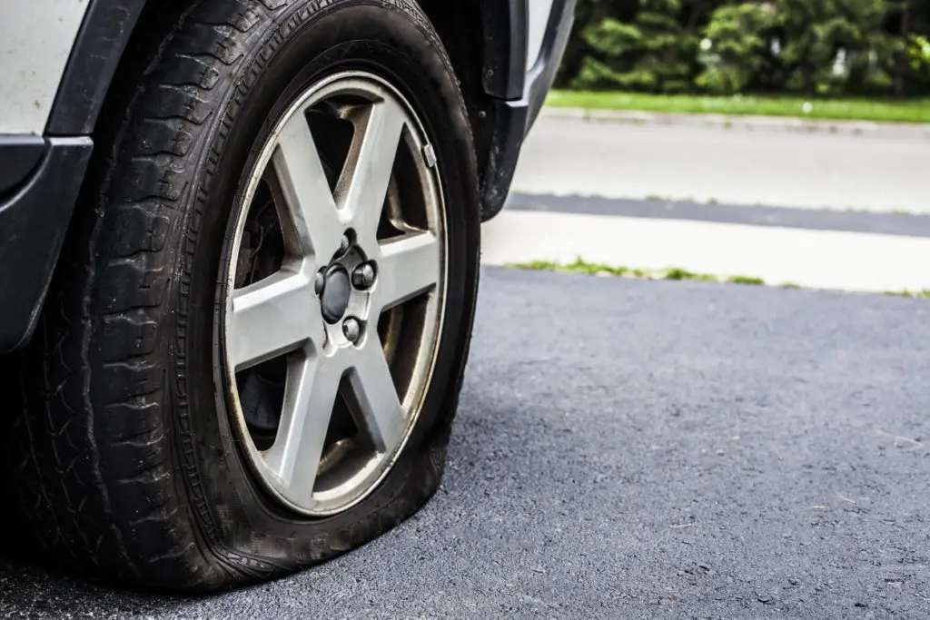 Car with a Flat Tire on the Road