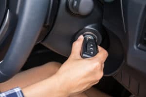 Woman placing her key into her vehicle's ignition