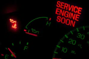 Service engine soon, check engine, oil pressure, and engine temperature lights on dashboard of a car or truck