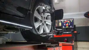 Car on stand with sensors on wheels for wheels alignment camber check in workshop of an automotive service station.