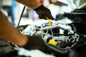 Close up of mechanic checking engine oil in a repair shop