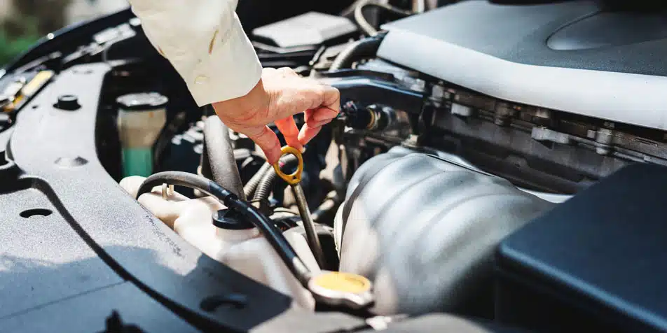 checking oil under hood of car