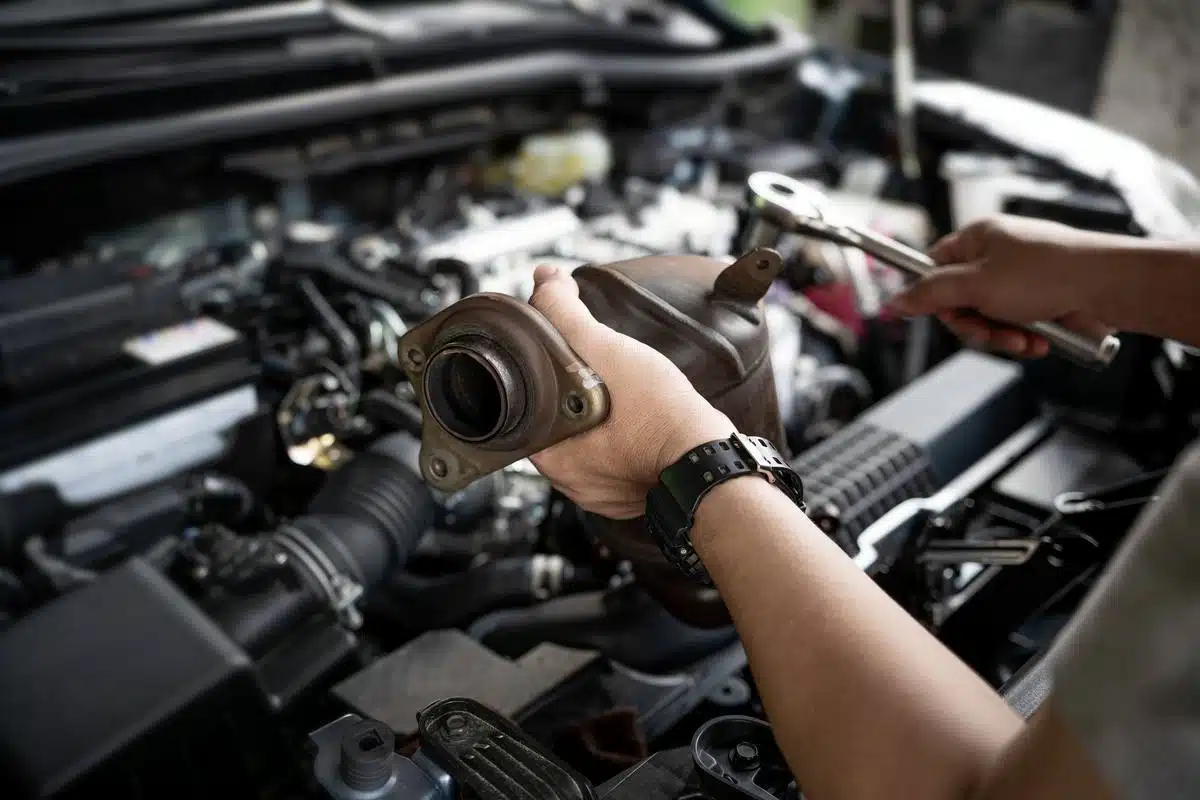 mechanic repairing catalytic converter